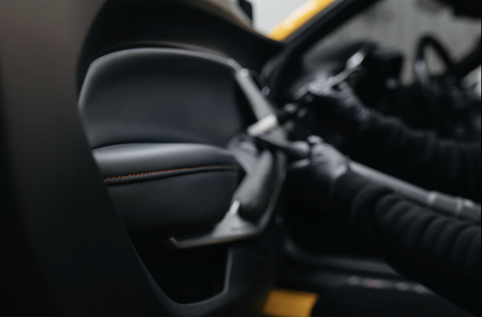 Close-up of detailed black leather interior with orange stitching